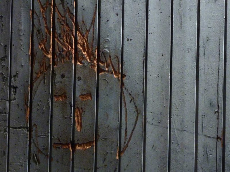 cara pintada escolpida a una porta antiga de fusta del rec igualada